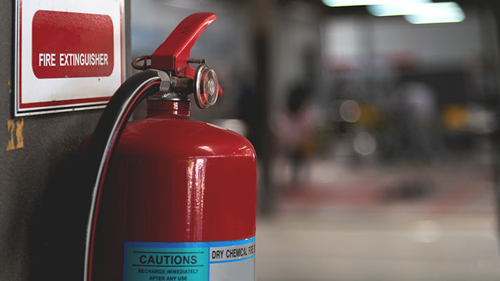 red fire extinguisher hanging on a wall