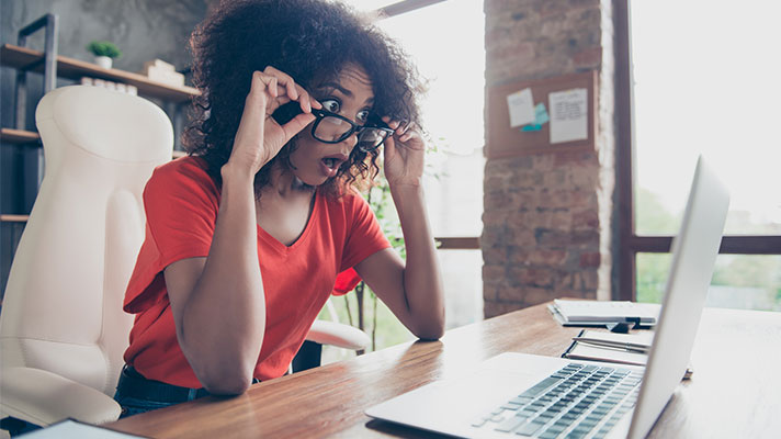 woman looking at computer shocked