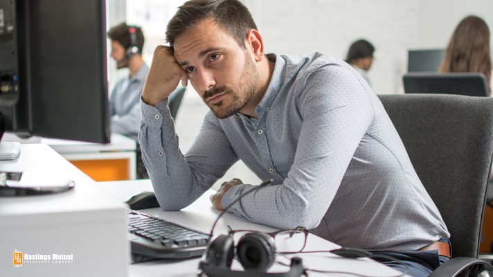 depressed man sitting at a workstation desk
