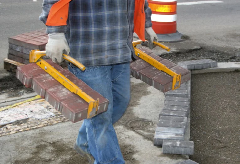 construction worker carrying paver blocks