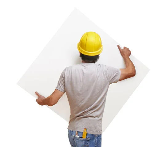 construction worker carrying a sheet of drywall