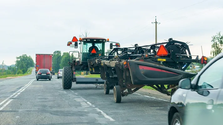 tractor driving on a busy road
