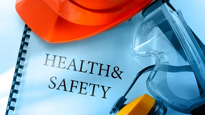 a health and safety manual with safety equipment around it