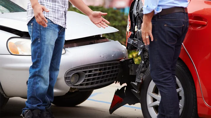 close up of two people standing in front of a rear end collision