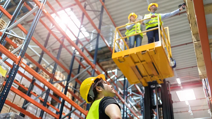 warehouse employees on an elevated platform