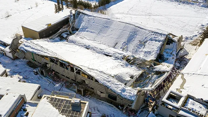 building with a collapsed roof due to snow