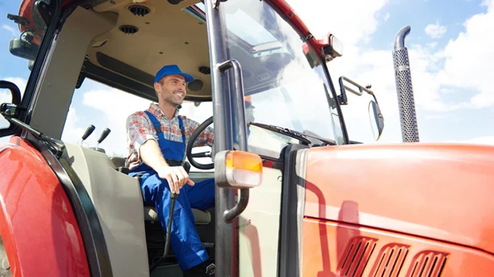 close up of a smiling farmer driving a tractor