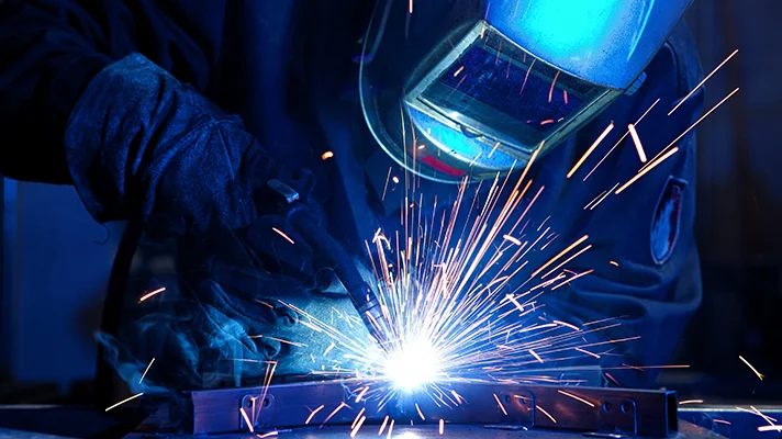 a welder making a weld with a shower of sparks