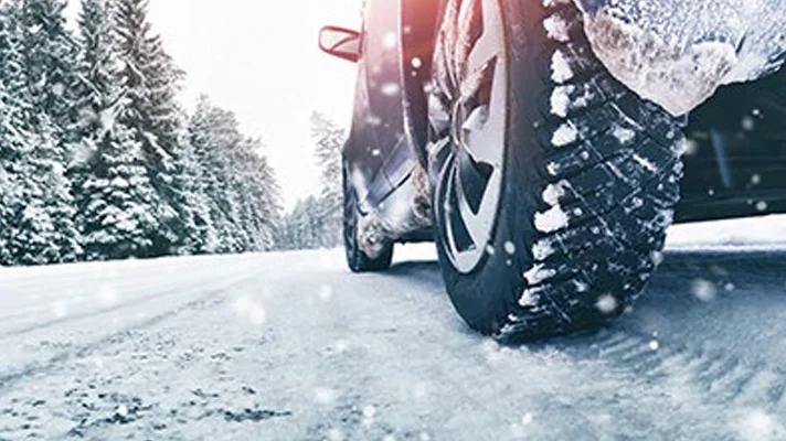 close up view of car tires driving in the snow
